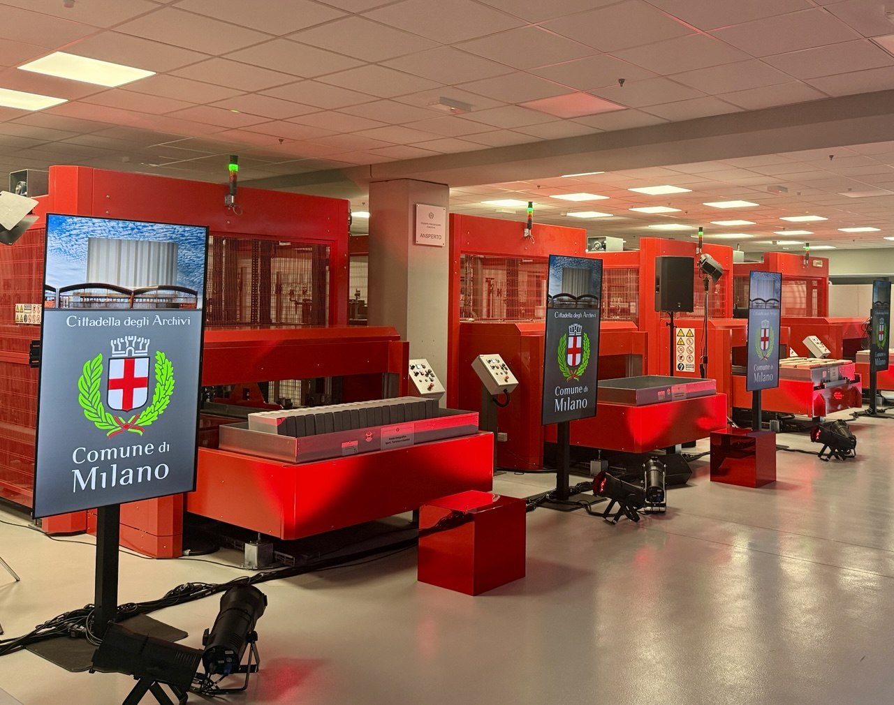 Vista del nuovo polo archivistico della Cittadella degli Archivi di Milano: le macchine archivistiche rosse del sistema automatizzato e i totem digitali con lo stemma del Comune di Milano